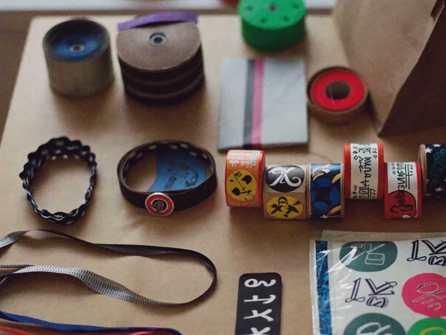 Cintas, pulseras, lanyards y stickers preparados sobre una mesa de trabajo